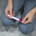 Frau betrachtet Schwangerschaftstest