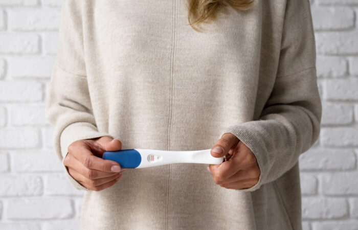 Frau mit positivem Schwangerschaftstest